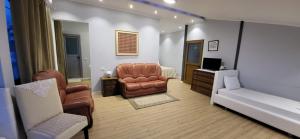 a living room with a couch and a chair and a bed at Jon rooms in Himare