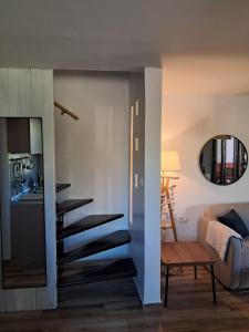 a staircase in a living room with a couch and a table at Pine House Novalja in Gajac