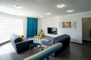 a living room with two blue couches and a tv at Holiday Apartments Amarilis in Pakoštane