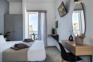a bedroom with a bed and a desk and windows at Star Apartments in Rethymno
