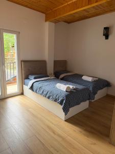 two beds in a room with a window at Bujtina Lugina e vjosës in Përmet