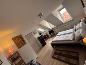 an attic bedroom with a bed and a room with at Bright studio-flat near station - Bayreuth in Bayreuth
