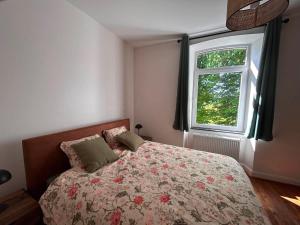a bedroom with a bed and a window at Le Clos des Marronniers in Léglise