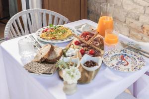 a white table with a breakfast of food and orange juice at casa PRIANI in Krasica