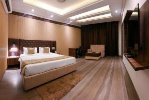 a hotel room with a bed and a television at The Orlov in Babarpur