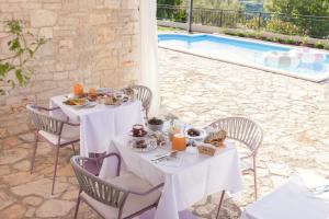 a table with food on it next to a pool at casa PRIANI in Krasica