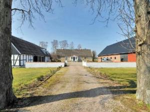 a dirt road with two houses and two trees at Bräcke Gård in Höganäs