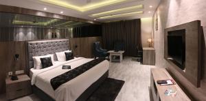 a hotel room with a large bed and a television at The Orlov in Babarpur