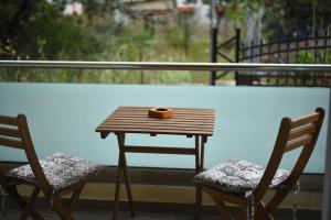a wooden table and two chairs on a balcony at Laida studios in Prinos