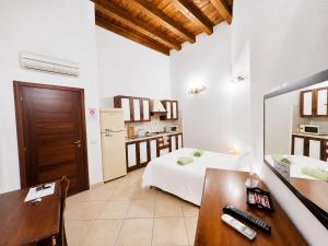 a bedroom with a bed and a desk and a kitchen at L'Antica Torre Caralis Holiday in Cagliari