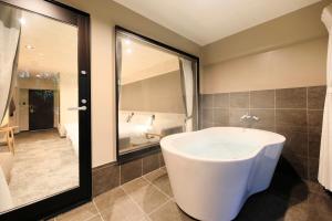 a bathroom with a large tub and a bedroom at Merveille Hakone Gora in Hakone +44 photos