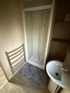 a bathroom with a shower and a toilet and a sink at Elite Retreat Caravan in Blackpool +4 photos