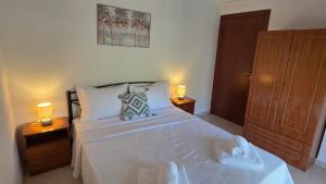 a bedroom with a large white bed with two lamps at Anemos House Sykia Halkidiki in Sykia Chalkidikis