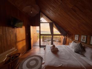 a bedroom with a large bed in a wooden room at Dynasty Glamping Bedugul in Bedugul +9 photos