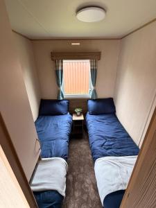 a small room with two beds and a window at Elite Retreat Caravan in Blackpool