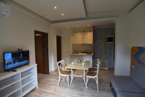 a living room with a table and chairs and a kitchen at Laida studios in Prinos