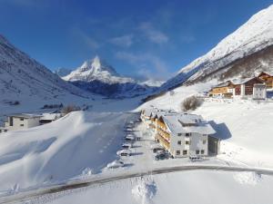 a resort in the snow with a mountain in the background at Hotel Sabine in Galtür