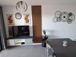 a living room with a flat screen tv and a table at T2 cozy vue mer in Pietrosella