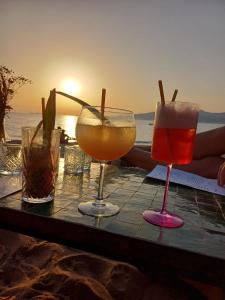 a table with three glasses of drinks on the beach at T2 cozy vue mer in Pietrosella +10 photos