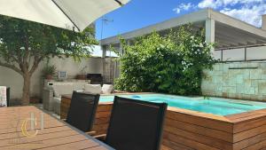 a swimming pool with two chairs and an umbrella at Cristina Home in Taranto