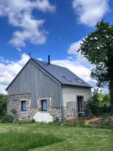 a barn with a gray roof on a grass field at Le Pressoir des Maisons de Blanche in Lengronne