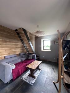 a living room with a couch and a staircase at Le Pressoir des Maisons de Blanche in Lengronne