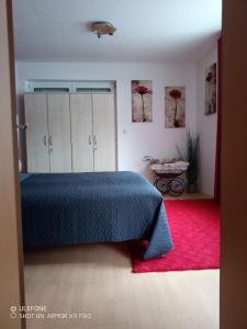 a bedroom with a blue bed and a red rug at Ferienwohnung Kiefernwald in Mechernich