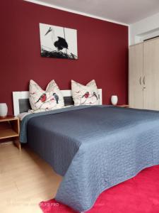 a bedroom with a large bed with red walls at Ferienwohnung Kiefernwald in Mechernich