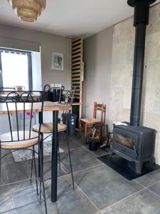 a living room with a stove and a table and chairs at Le Pressoir des Maisons de Blanche in Lengronne