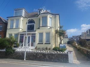 a white house with a fence in front of it at Smugglers Rest in Newquay