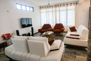 a living room with white couches and chairs at Solana Pearl Beach Private Villa in Tiwi