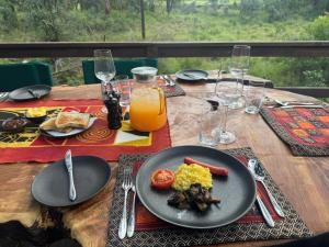 a wooden table with a plate of food on it at Ndzhaka Tented Camp in Manyeleti Game Reserve