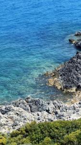 an aerial view of a rocky shore with blue water at Sewelo Suites - Beachfront Boutique Suites in Skinária