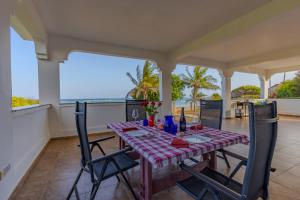a dining room with a table and chairs and the ocean at Solana Pearl Beach Private Villa in Tiwi