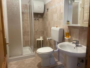 a bathroom with a toilet and a sink and a shower at Nonna Antonietta in San Teodoro