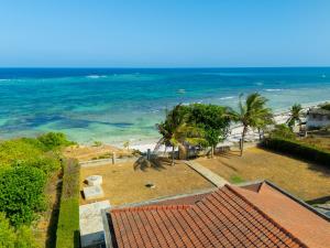a view of a beach with palm trees and the ocean at Solana Pearl Beach Private Villa in Tiwi