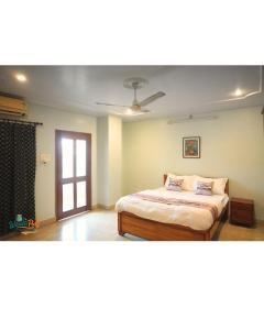 a bedroom with a bed and a ceiling fan at Wanderpals Guwahati in Guwahati