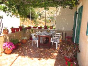 Kalotina's Apartments في Emborios: طاولة وكراسي على فناء مع نباتات الفخار