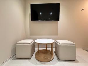 a room with two stools and a table and a tv at The hotel 1997 - 더호텔 1997 in Seoul +17 photos