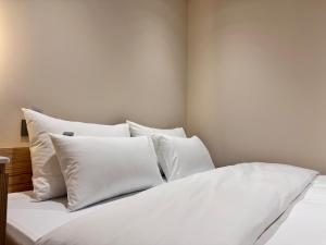 a white bed with white pillows in a bedroom at The hotel 1997 - 더호텔 1997 in Seoul