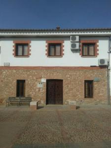 un edificio con un banco delante de él en Casa Rural Pastora Marcela, en Saceruela