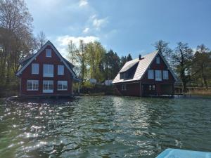 two houses sitting on top of a body of water at Seehaeuser am Lindenhof in Lychen