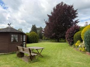 a wooden bench sitting in the grass next to a shed at Landhaus zur Sonne in Bad Camberg