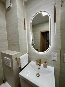 a bathroom with a sink and a mirror at Justinrent PALATIUM 31 in Legnica +12 photos