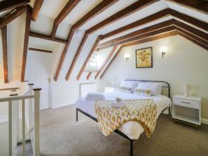 a bedroom with a bed in a room with wooden ceilings at Miranda Cottage in Polperro