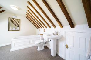 a bathroom with a toilet and a sink and a tub at Miranda Cottage in Polperro +23 photos