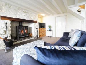a living room with a couch and a fireplace at Miranda Cottage in Polperro