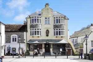 a building on a street with people in front of it at Miranda Cottage in Polperro