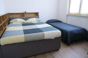 a bedroom with a large bed and two beds sidx sidx sidx at Lake Iseo Apartment - Taxo4 in Paratico