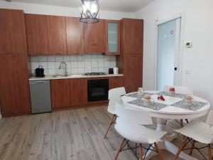 a kitchen with a white table and white chairs at Lake Iseo Apartment - Taxo4 in Paratico